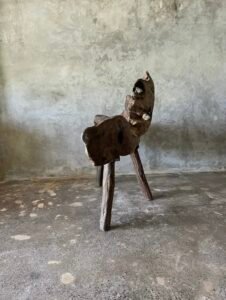 Banc en teck ancien avec design tripode et dossier ajouré, pièce artisanale unique.