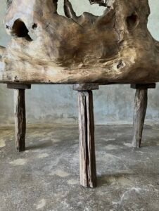 Banc en teck ancien avec design tripode et dossier ajouré, pièce artisanale unique.
