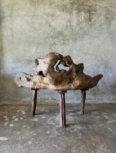 Banc en teck ancien avec design tripode et dossier ajouré, pièce artisanale unique.