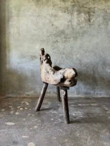 Banc en teck ancien avec design tripode et dossier ajouré, pièce artisanale unique.