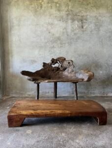 Banc en teck ancien avec design tripode et dossier ajouré, pièce artisanale unique.