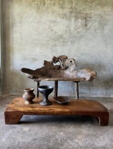 Banc en teck ancien avec design tripode et dossier ajouré, pièce artisanale unique.
