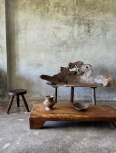 Banc en teck ancien avec design tripode et dossier ajouré, pièce artisanale unique.