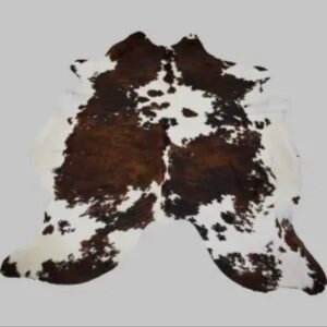 Tapis naturel en peau de vache, tanné artisanalement en France, pièce unique aux motifs bruts.