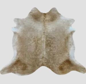 Tapis naturel en peau de vache, tanné artisanalement en France, pièce unique aux motifs bruts.