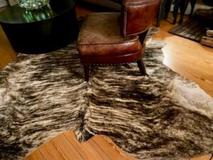 Tapis naturel en peau de vache, tanné artisanalement en France, pièce unique aux motifs bruts.