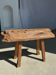 Petit banc artisanal en teck blond quadripode, pièce unique au style brutaliste, éthique et durable, idéal en déco intérieure