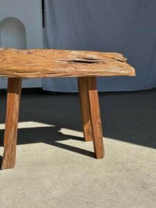 Petit banc artisanal en teck blond quadripode, pièce unique au style brutaliste, éthique et durable, idéal en déco intérieure