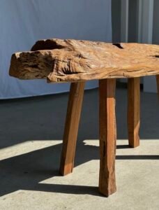 Petit banc artisanal en teck blond quadripode, pièce unique au style brutaliste, éthique et durable, idéal en déco intérieure