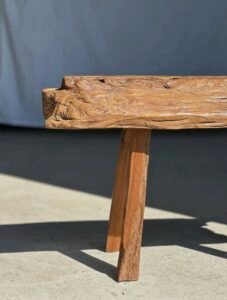 Petit banc artisanal en teck blond quadripode, pièce unique au style brutaliste, éthique et durable, idéal en déco intérieure