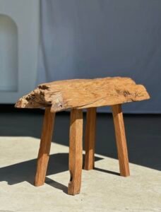 Petit banc artisanal en teck blond quadripode, pièce unique au style brutaliste, éthique et durable, idéal en déco intérieure